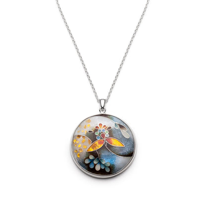 Round pendant with floral design on a silver chain against a white background