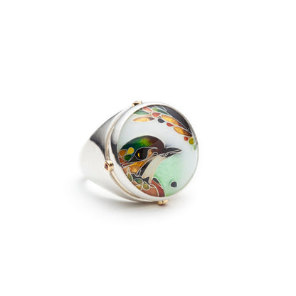 Silver ring with a circular design featuring a bird on a white background