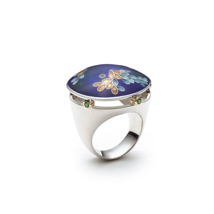 Silver ring with a blue stone featuring floral designs on a white background